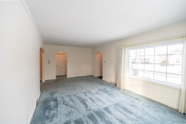 unfurnished living room featuring arched walkways, carpet flooring, crown molding, and a textured ceiling