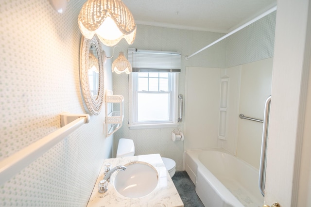 bathroom with shower / tub combination, a sink, toilet, and wallpapered walls