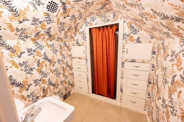 bathroom featuring wallpapered walls, visible vents, and a sink