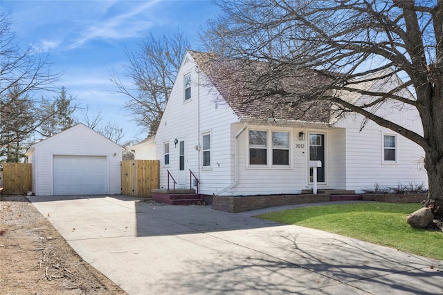 view of front of property with a garage, an outbuilding, concrete driveway, and fence