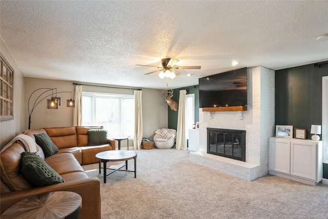 living room with carpet floors, a brick fireplace, and a ceiling fan