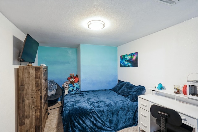 carpeted bedroom with visible vents and a textured ceiling