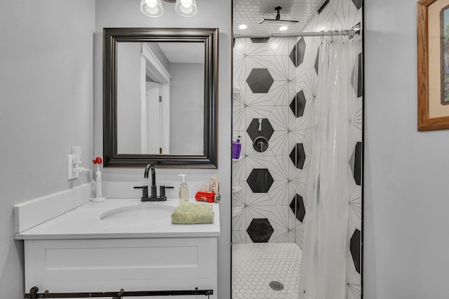 bathroom with a tile shower and vanity