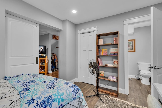 bedroom with a closet, baseboards, and wood finished floors