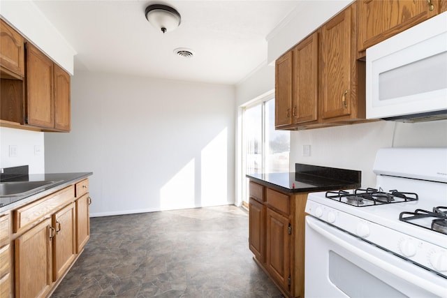 kitchen with visible vents, brown cabinetry, ornamental molding, a sink, and white appliances