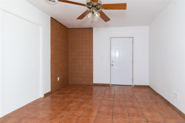 spare room featuring a ceiling fan, light tile patterned flooring, and visible vents