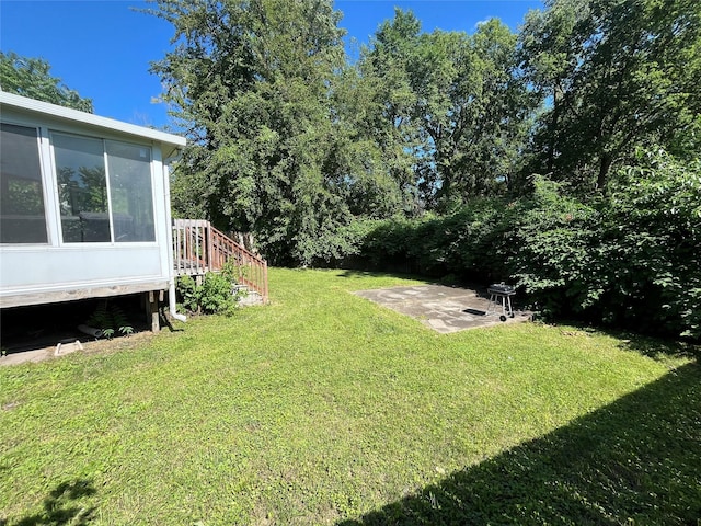 2809 Easton Blvd, Des Moines, IA 50317 - view of grassy yard featuring a patio and a sunroom