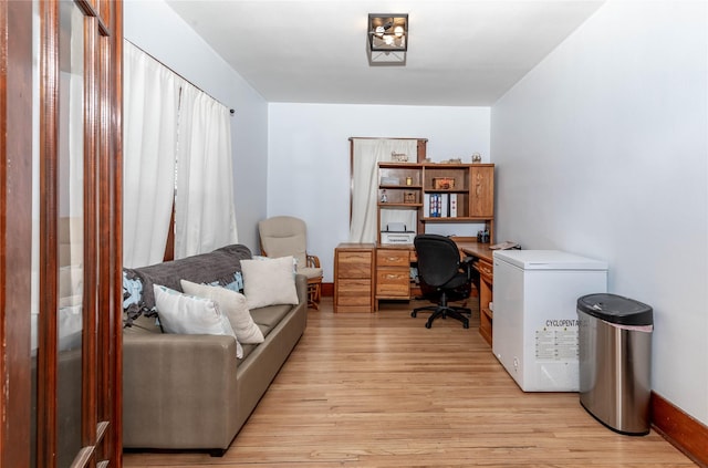 office space with light wood-style floors and baseboards