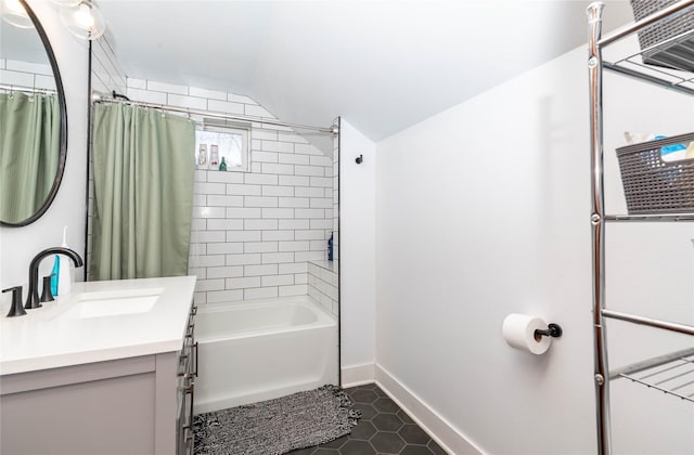 full bath with shower / tub combo, vaulted ceiling, vanity, baseboards, and tile patterned floors