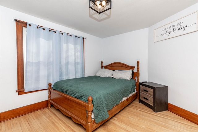 bedroom with baseboards and light wood finished floors