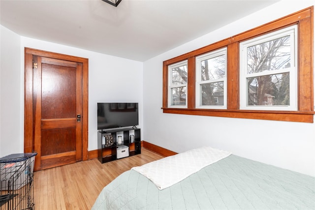 bedroom with light wood-type flooring and baseboards