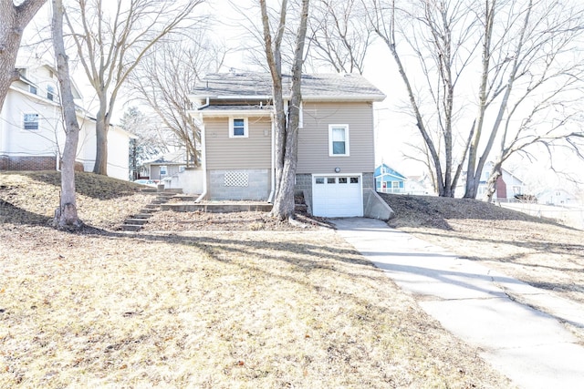 view of front of house with a garage, driveway, and stairs
