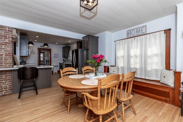 dining room featuring light wood-style flooring and crown molding