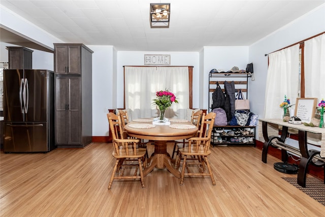 dining space with baseboards and light wood-style floors