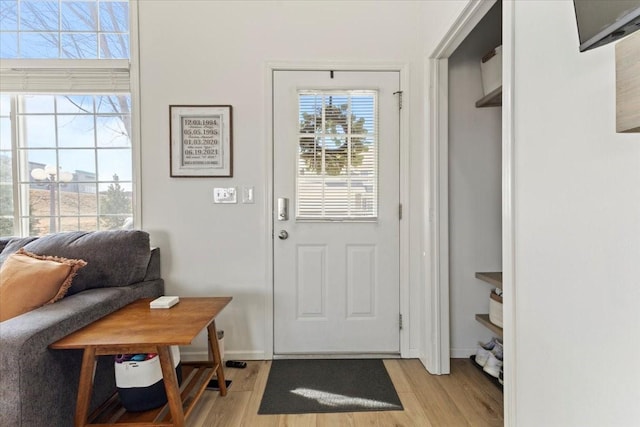 doorway to outside with light wood-type flooring and baseboards