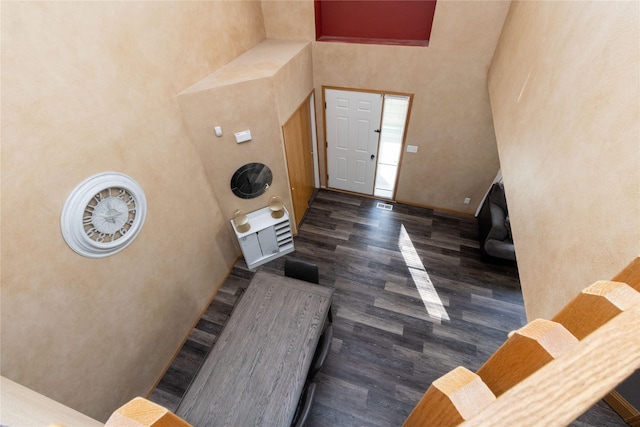 foyer with wood finished floors, a high ceiling, and stairs