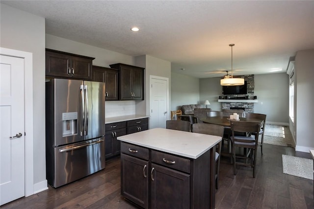 kitchen with dark brown cabinetry, light countertops, dark wood finished floors, and stainless steel fridge with ice dispenser