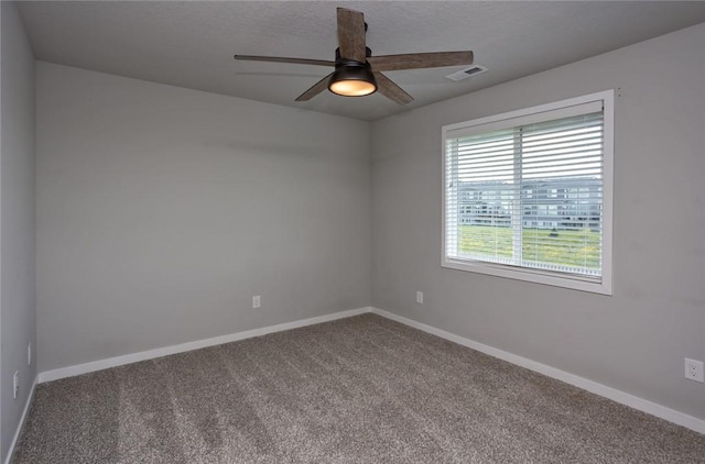 empty room with carpet floors, visible vents, ceiling fan, a textured ceiling, and baseboards