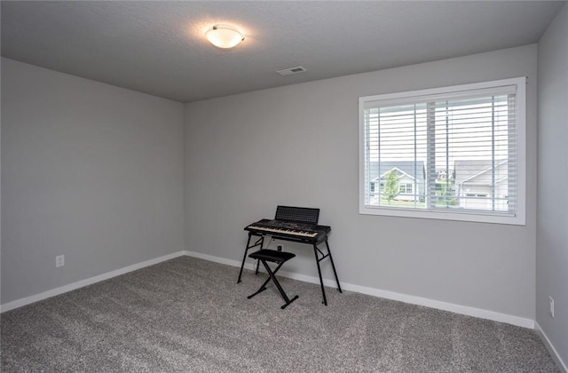 carpeted home office featuring baseboards, visible vents, and a textured ceiling