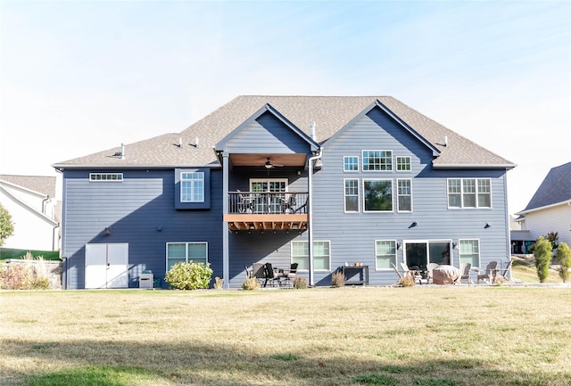 rear view of house with roof with shingles, ceiling fan, a patio, and a lawn