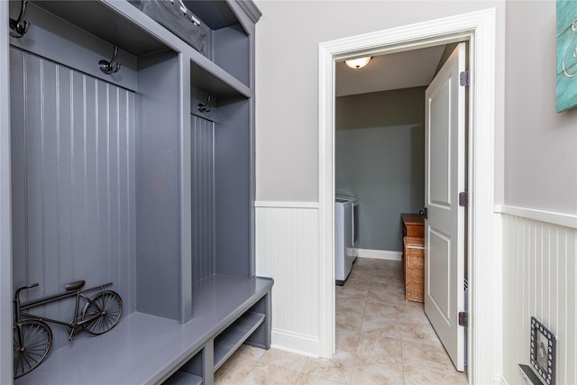 mudroom with a wainscoted wall, light tile patterned flooring, and washer and dryer