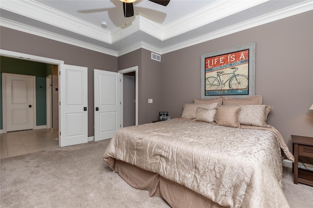 tiled bedroom featuring visible vents, a raised ceiling, a ceiling fan, crown molding, and carpet flooring