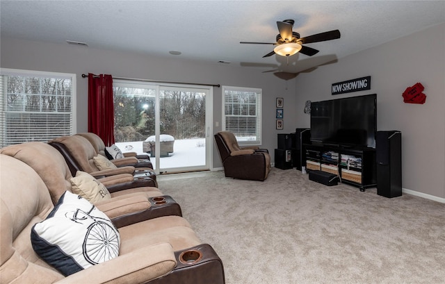 living room featuring a textured ceiling, carpet flooring, visible vents, baseboards, and a ceiling fan