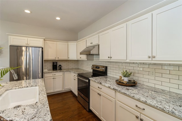 kitchen featuring under cabinet range hood, dark wood-type flooring, white cabinetry, appliances with stainless steel finishes, and tasteful backsplash