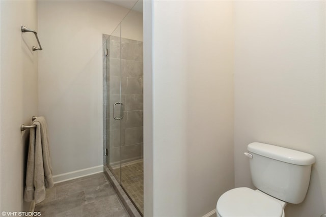 full bathroom featuring a stall shower, baseboards, and toilet