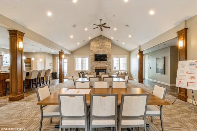 dining area featuring a fireplace, decorative columns, light colored carpet, high vaulted ceiling, and baseboards