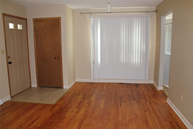 entryway with baseboards and wood finished floors