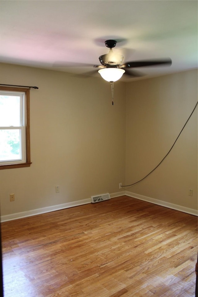 unfurnished room featuring visible vents, ceiling fan, light wood-style flooring, and baseboards