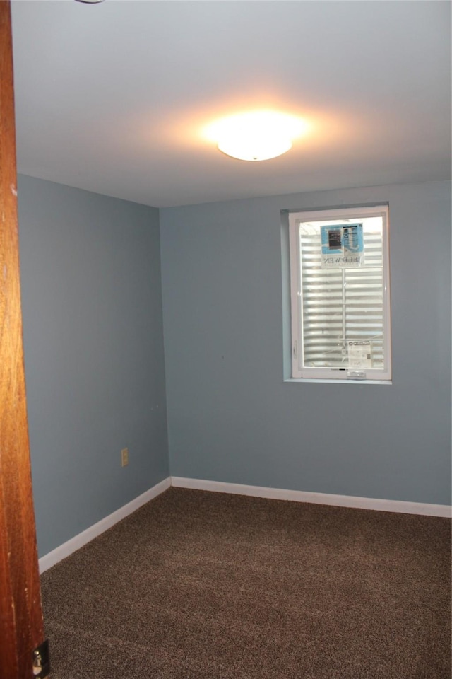 empty room featuring carpet floors and baseboards