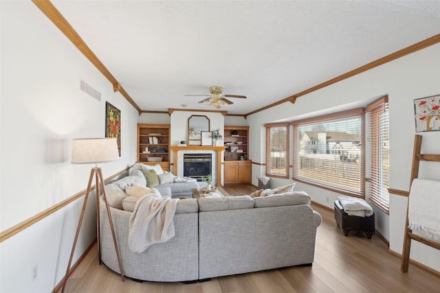 365 Williamson Ct, Pleasant Hill, IA 50327 - living area with crown molding, wood finished floors, a glass covered fireplace, baseboards, and visible vents