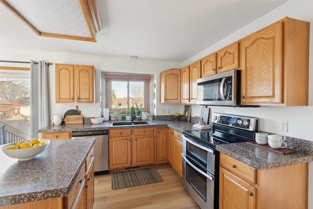 365 Williamson Ct, Pleasant Hill, IA 50327 - kitchen with light wood-type flooring, stainless steel appliances, a sink, and a textured ceiling