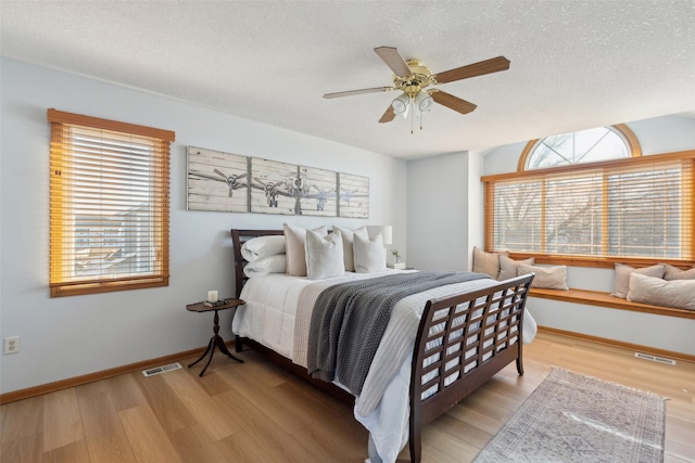 365 Williamson Ct, Pleasant Hill, IA 50327 - bedroom featuring wood finished floors, visible vents, baseboards, and multiple windows