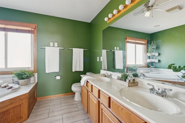 365 Williamson Ct, Pleasant Hill, IA 50327 - bathroom featuring a garden tub, a ceiling fan, toilet, and a sink