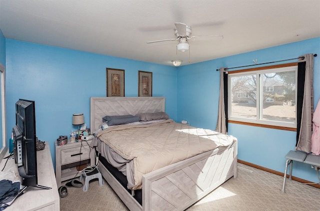 bedroom with ceiling fan, baseboards, and light colored carpet