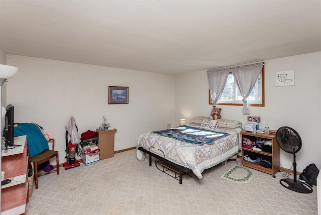 bedroom featuring light carpet, a textured ceiling, and baseboards