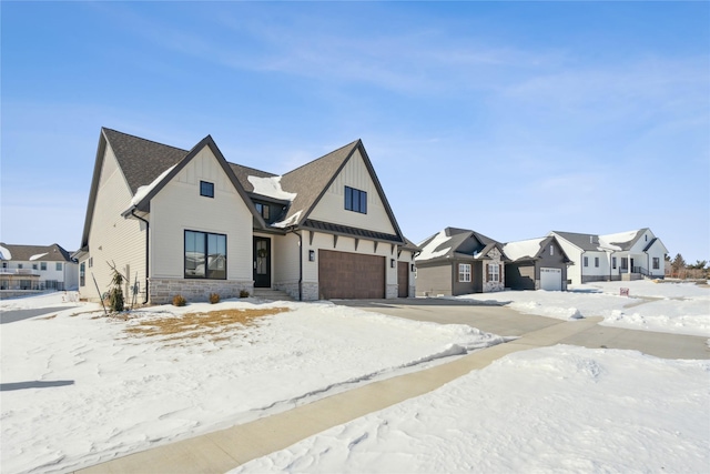 modern inspired farmhouse featuring stone siding, board and batten siding, an attached garage, and a residential view