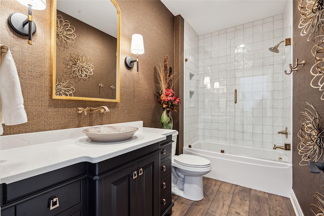 bathroom featuring shower / bathtub combination, vanity, toilet, and wood finished floors