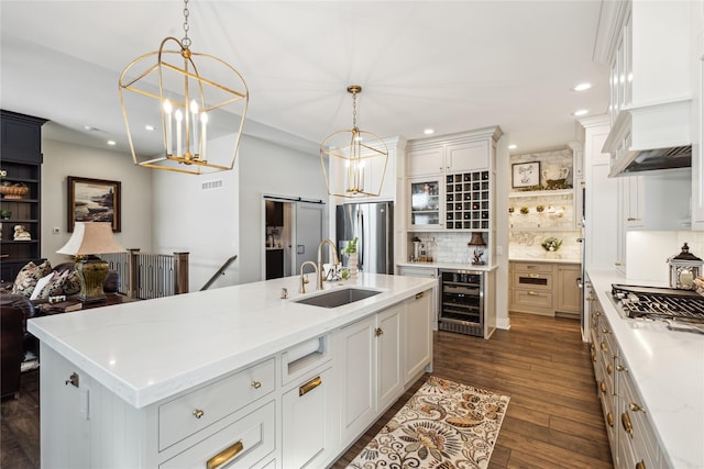 kitchen featuring a barn door, dark wood finished floors, wine cooler, stainless steel appliances, and a sink