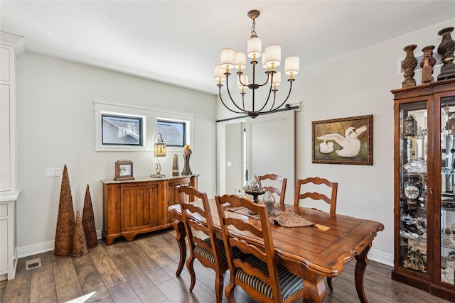 dining space featuring baseboards, wood finished floors, and a notable chandelier