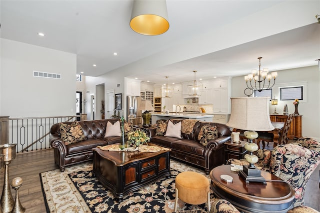 living area with recessed lighting, wood finished floors, visible vents, and a notable chandelier