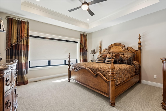 bedroom with visible vents, a tray ceiling, ornamental molding, and light colored carpet