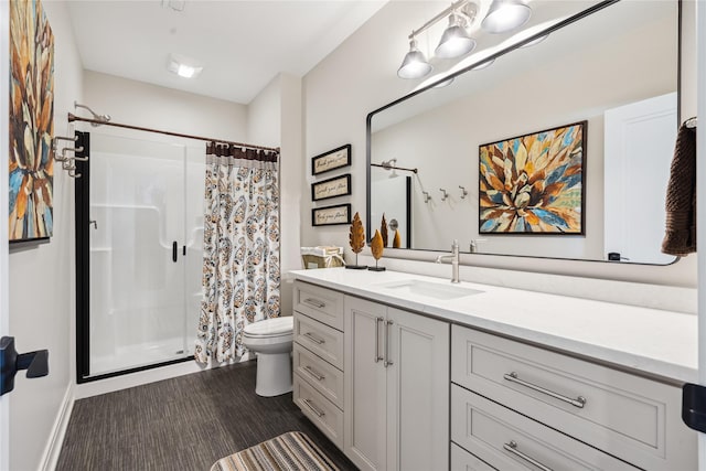 full bathroom featuring toilet, a stall shower, and vanity