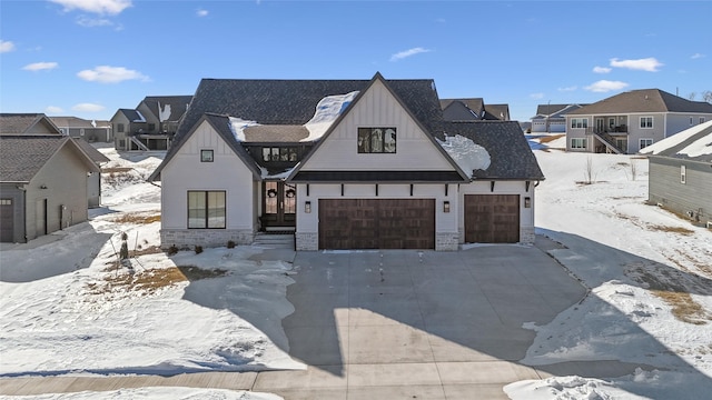 modern farmhouse style home with stone siding, a residential view, concrete driveway, and a garage