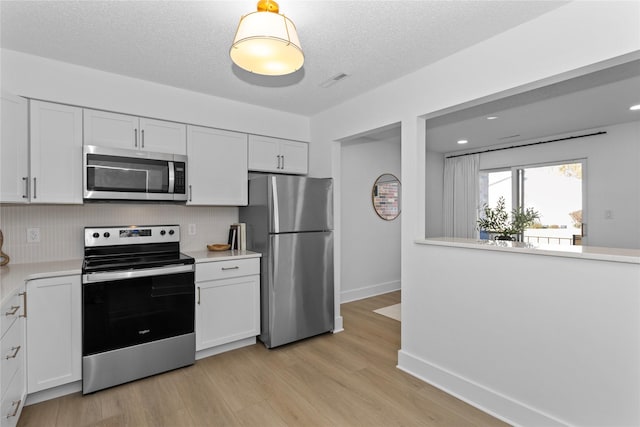 kitchen featuring white cabinetry, appliances with stainless steel finishes, and light countertops