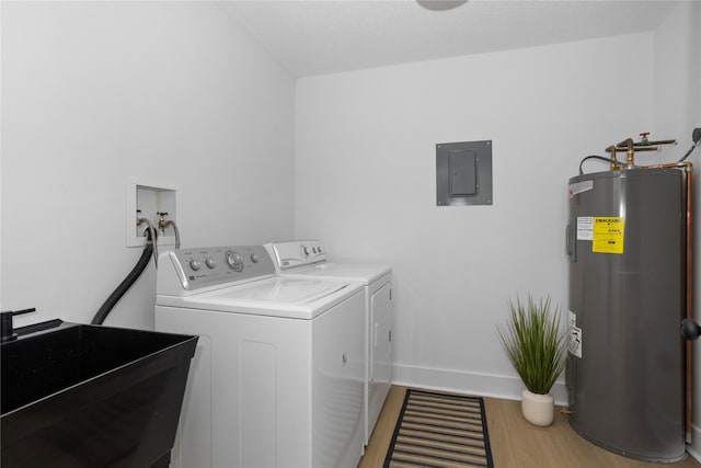 laundry room with laundry area, light wood-type flooring, washing machine and dryer, water heater, and a sink