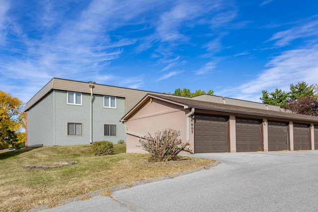 view of home's exterior featuring a garage and a lawn